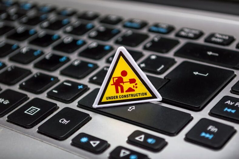 A miniature under construction sign placed on a laptop keyboard symbolizing digital development